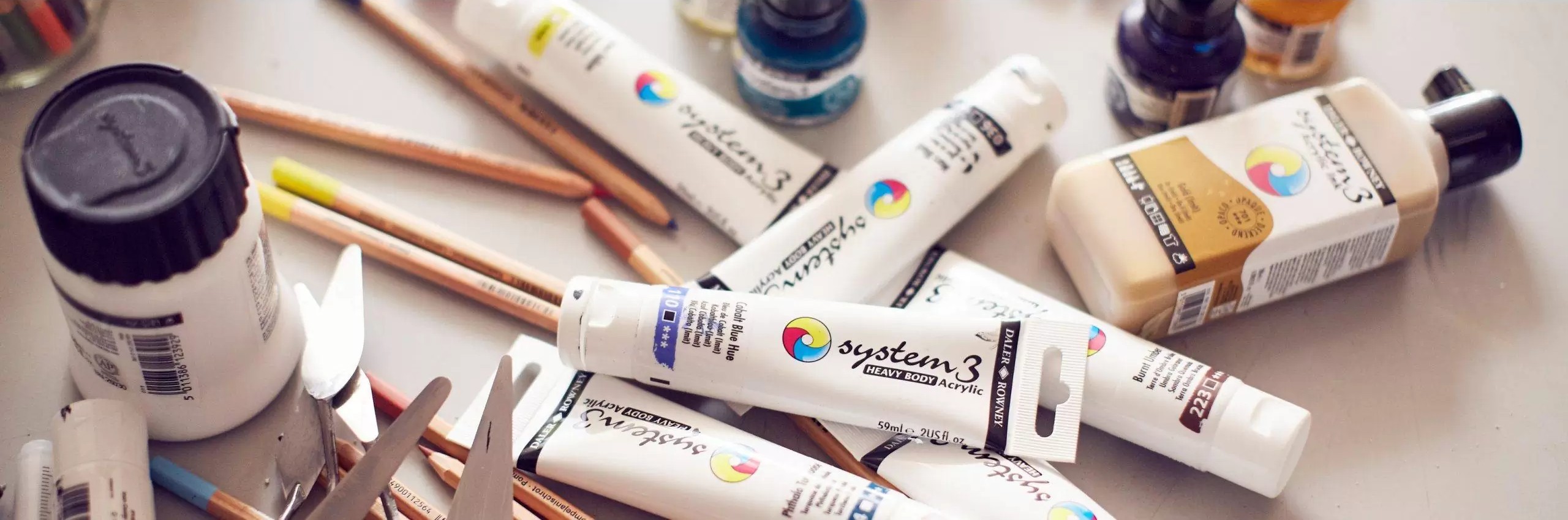 Studio acrylic paint tubes, palette knives and artist supplies